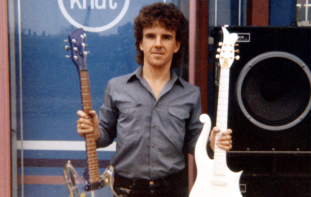 Dave Russan holding the white Cloud Guitar created as a prop for the Purple Rain movie